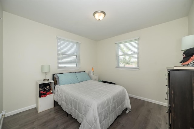 bedroom with dark wood-style flooring and baseboards