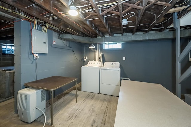 laundry room with laundry area, wood finished floors, washer and dryer, and electric panel