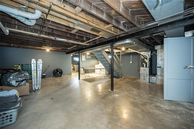 basement featuring heating unit and stairway