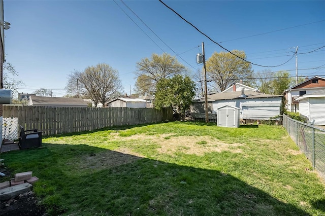 view of yard featuring an outbuilding, a fenced backyard, and a shed