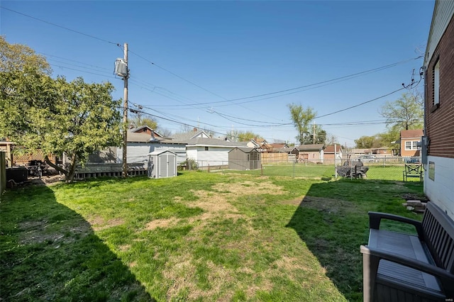 view of yard with a storage shed, a fenced backyard, and an outdoor structure