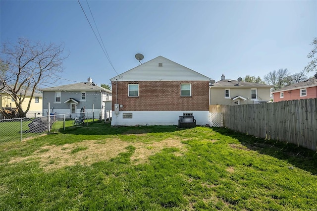 rear view of property with a yard, a fenced backyard, and brick siding