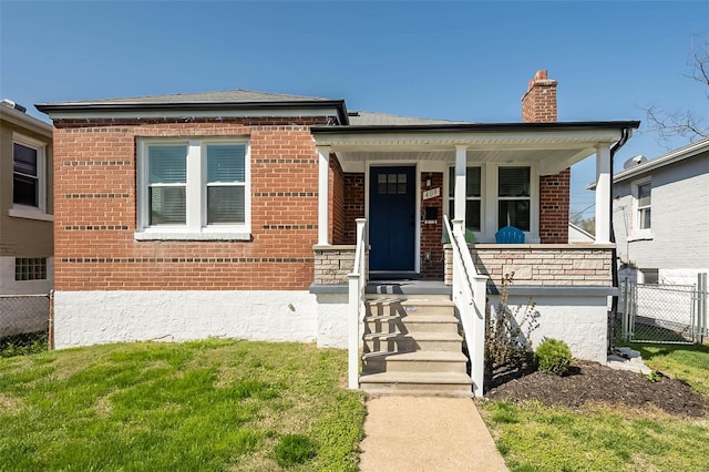 bungalow-style home featuring fence, a porch, brick siding, and a chimney