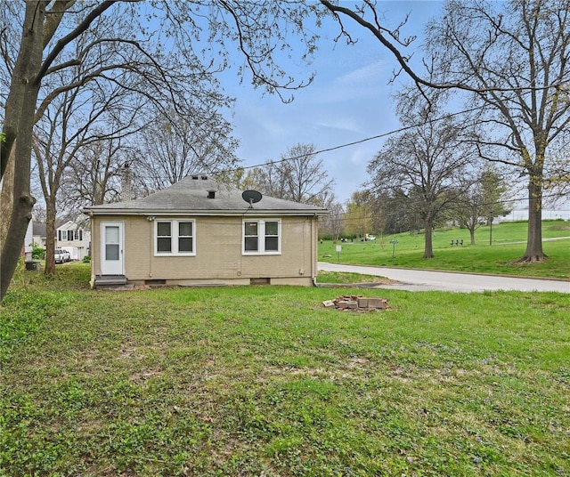 back of house featuring a yard and a chimney