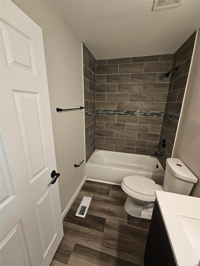 bathroom featuring shower / washtub combination, wood finished floors, visible vents, toilet, and vanity