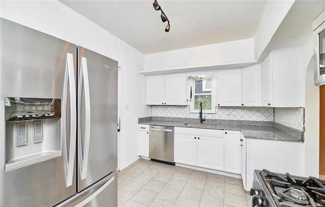 kitchen featuring a sink, appliances with stainless steel finishes, white cabinetry, backsplash, and light tile patterned flooring