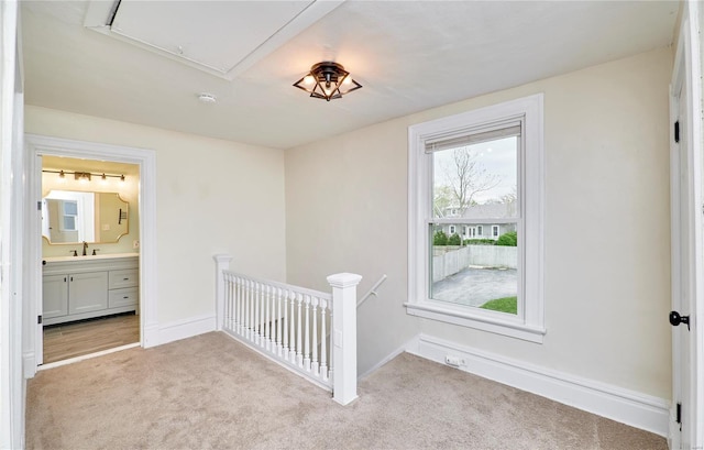 interior space with a sink, baseboards, and attic access