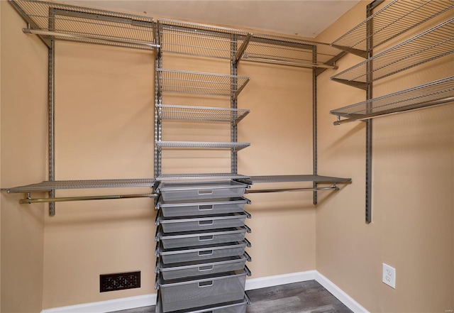 spacious closet with dark wood-type flooring