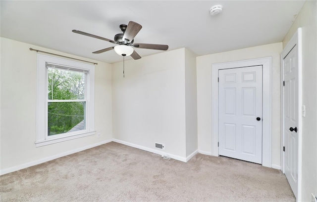 unfurnished room featuring visible vents, baseboards, a ceiling fan, and carpet