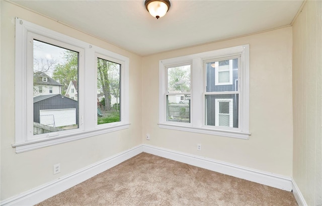 carpeted empty room featuring baseboards