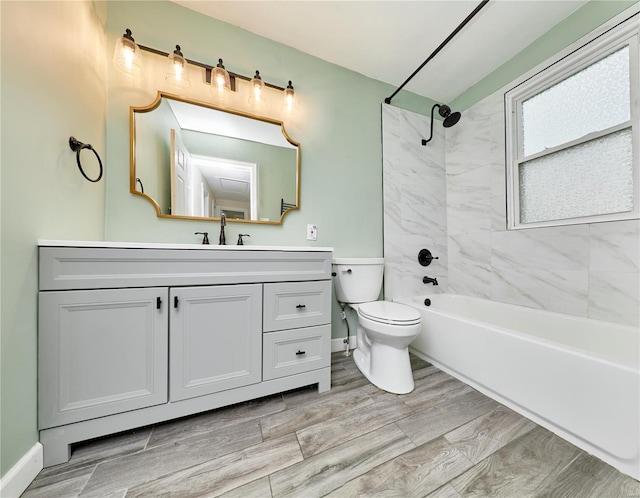 full bath featuring toilet, vanity, baseboards, and tub / shower combination