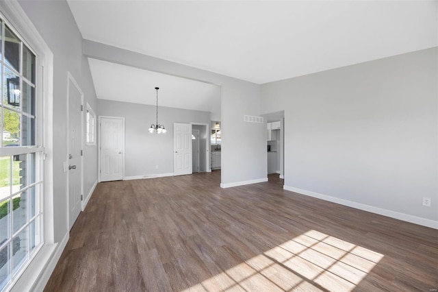 unfurnished living room with a chandelier, dark wood-style flooring, baseboards, and vaulted ceiling