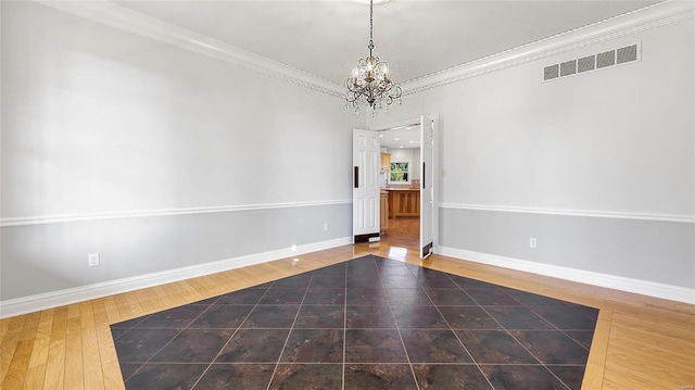 empty room with ornamental molding, baseboards, visible vents, a notable chandelier, and wood finished floors