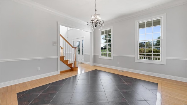 foyer featuring a notable chandelier, stairway, wood finished floors, baseboards, and ornamental molding
