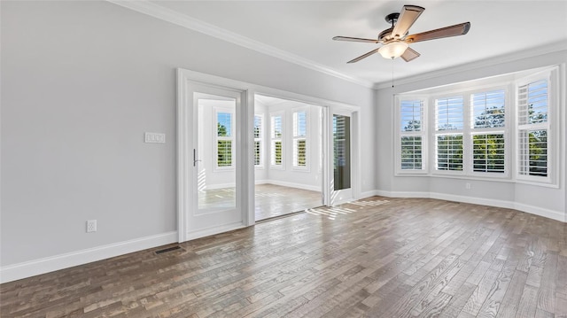 spare room featuring visible vents, a ceiling fan, wood finished floors, and crown molding