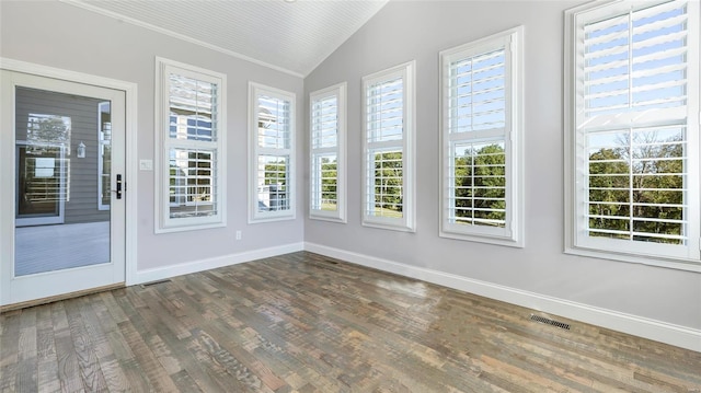 unfurnished sunroom featuring wood finished floors, baseboards, lofted ceiling, and visible vents