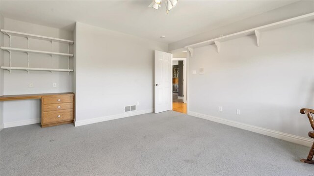 unfurnished bedroom with baseboards, carpet flooring, and visible vents