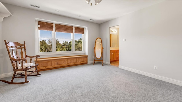 sitting room with light colored carpet, visible vents, and baseboards