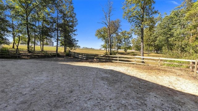 view of yard with fence and a rural view