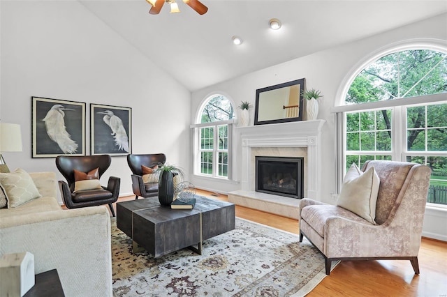 living room with recessed lighting, wood finished floors, a high end fireplace, high vaulted ceiling, and a ceiling fan