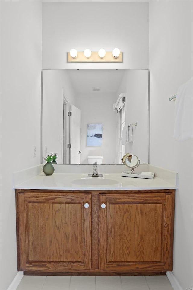 bathroom with visible vents, vanity, tile patterned flooring, and baseboards