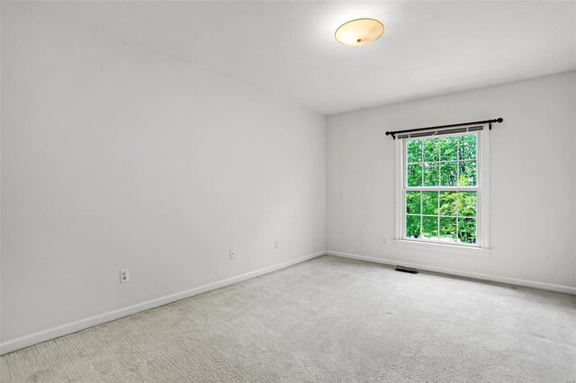 carpeted spare room with baseboards and visible vents