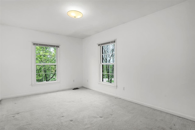 carpeted empty room featuring visible vents and baseboards