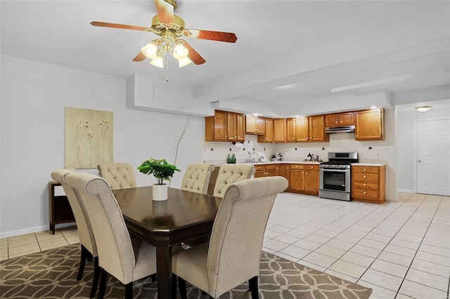 dining space featuring baseboards, ceiling fan, and light tile patterned flooring