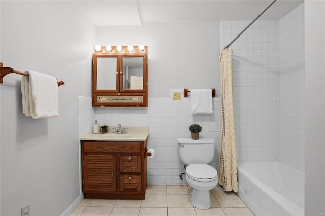 bathroom featuring shower / bathtub combination with curtain, vanity, toilet, tile patterned flooring, and wainscoting