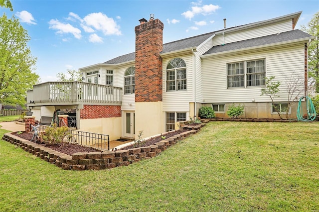 rear view of house featuring a chimney, a patio area, a wooden deck, and a lawn