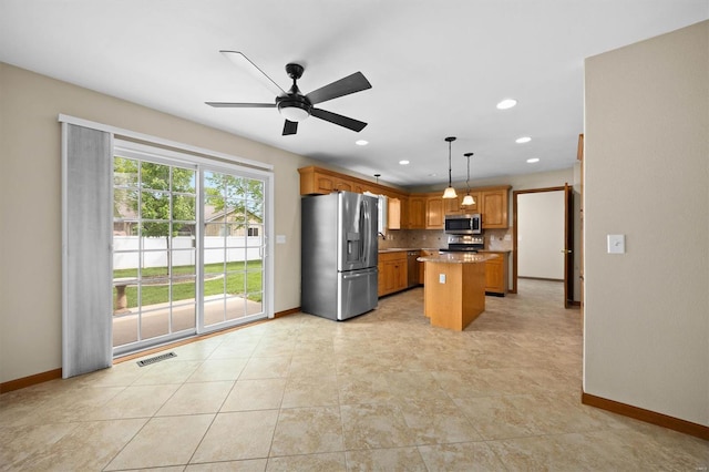 kitchen with visible vents, baseboards, a kitchen island, and stainless steel appliances
