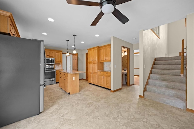 kitchen with recessed lighting, a ceiling fan, appliances with stainless steel finishes, and a kitchen island