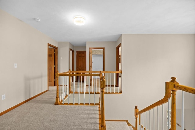interior space featuring baseboards, carpet flooring, and an upstairs landing