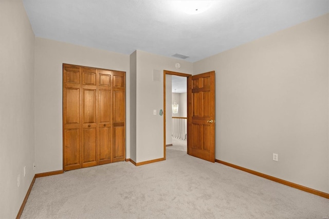 unfurnished bedroom featuring baseboards, carpet flooring, visible vents, and a closet