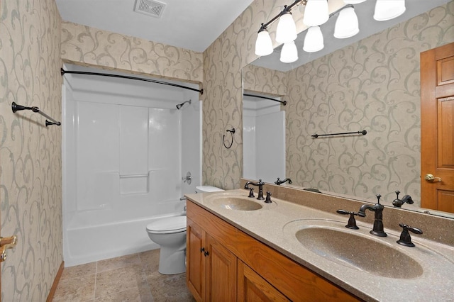 bathroom featuring a sink, wallpapered walls, and visible vents