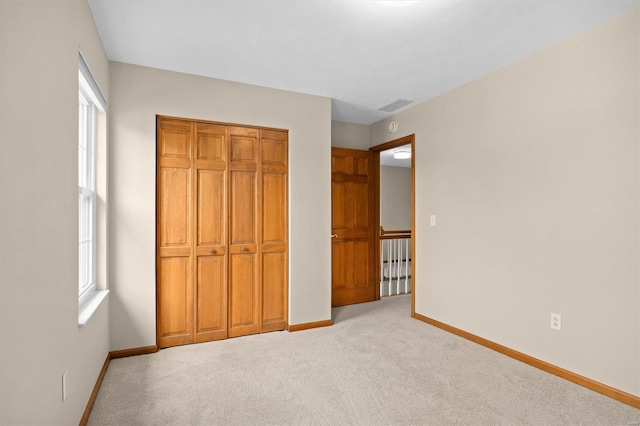 unfurnished bedroom featuring visible vents, carpet, baseboards, and multiple windows