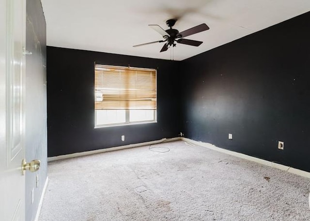carpeted spare room with baseboards and ceiling fan
