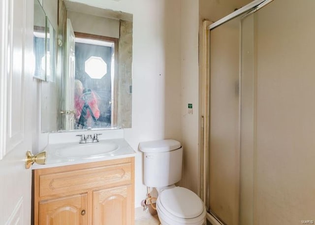 full bathroom featuring toilet, vanity, and a stall shower