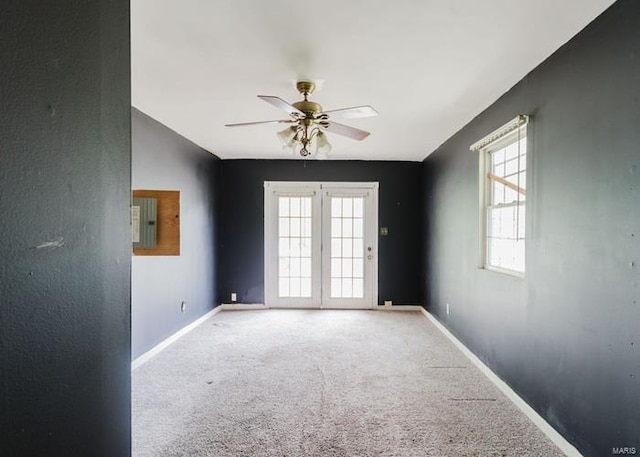 carpeted spare room with electric panel, baseboards, and a ceiling fan