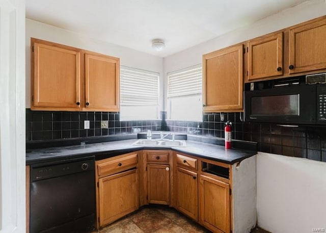 kitchen with brown cabinets, a sink, dark countertops, black appliances, and tasteful backsplash