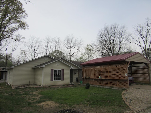 exterior space featuring driveway, an attached carport, and a yard