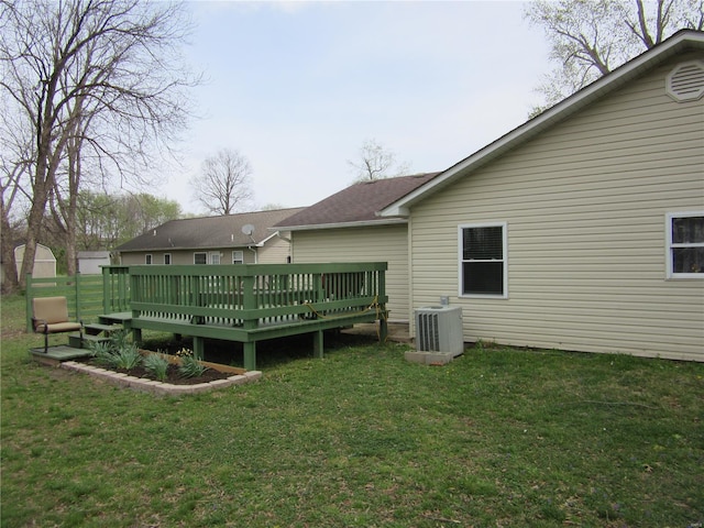 rear view of house featuring a lawn, central air condition unit, and a wooden deck