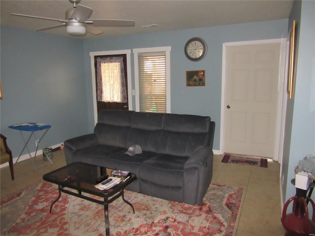 tiled living room featuring baseboards and ceiling fan
