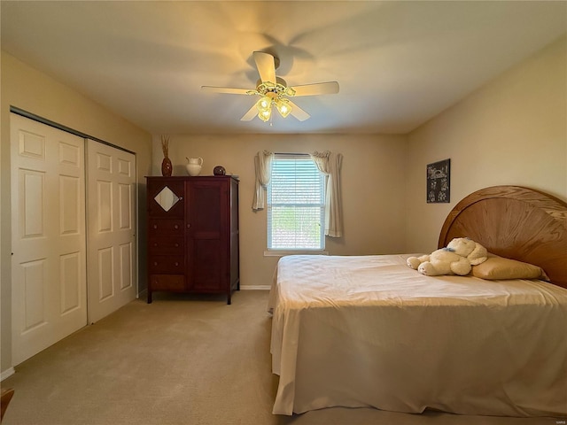 bedroom featuring ceiling fan, a closet, baseboards, and light carpet