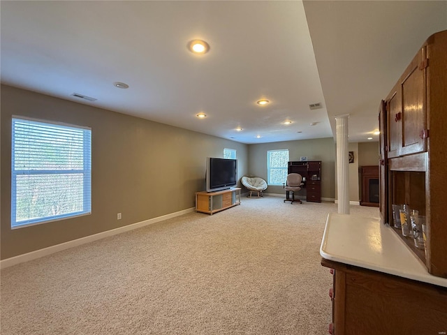 living room featuring recessed lighting, a fireplace with raised hearth, visible vents, baseboards, and light colored carpet