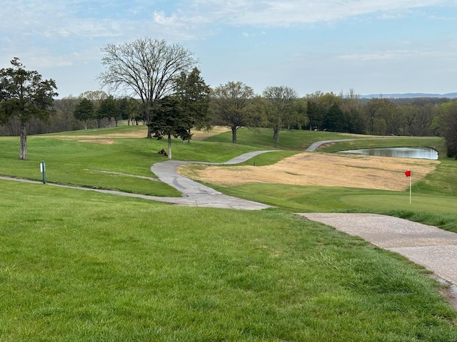 view of community with a lawn and a water view