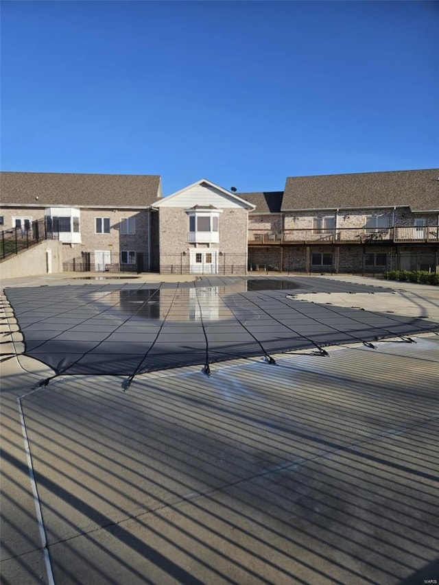 pool featuring a residential view, a patio, and fence