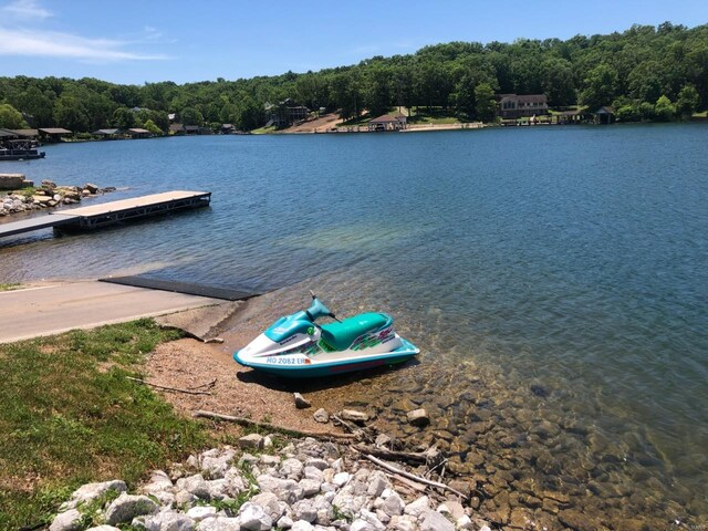 view of dock featuring a view of trees and a water view