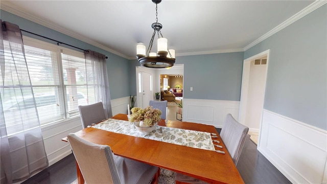 dining room featuring visible vents, ornamental molding, a chandelier, dark wood finished floors, and wainscoting