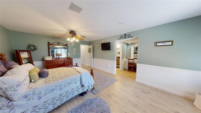 bedroom with visible vents, light wood-type flooring, and a ceiling fan